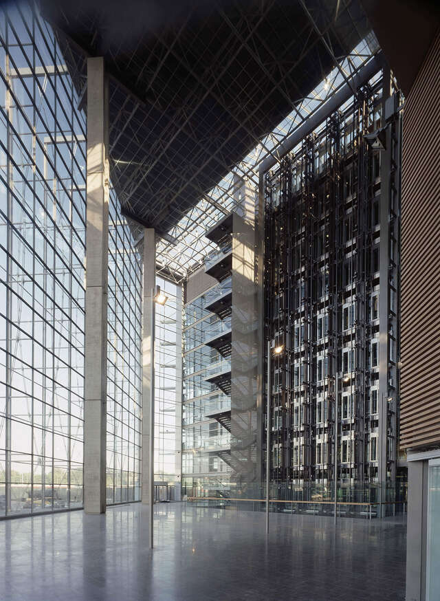 Entrance hall with high ceilings, glass and metal elements.