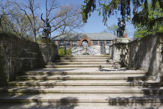 Wide stairs leading up to a low red brick building