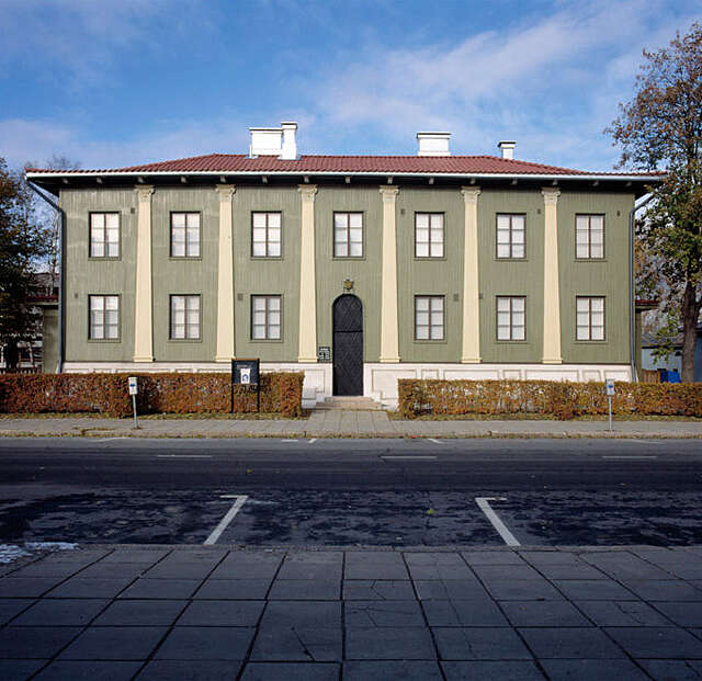 Green, two-storey, classical-looking house