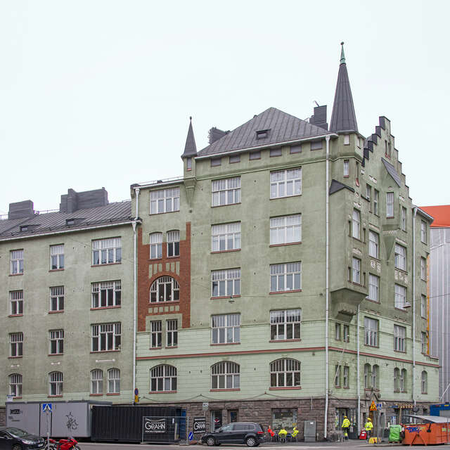 A green, decorative 6-storey building with tourettes.