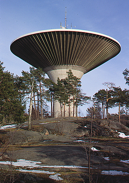 Mushroom-shaped water tower on top of a rock with trees