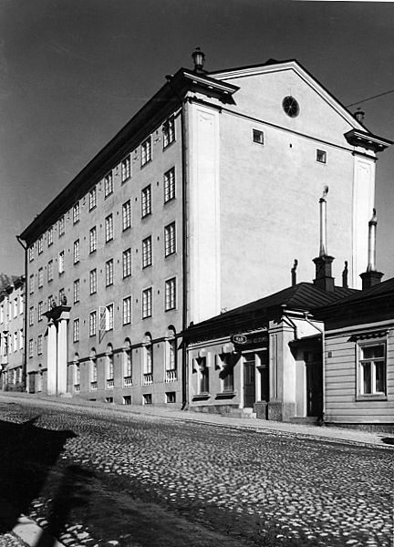 Black and white image of the apartment building, viewed diagonally.