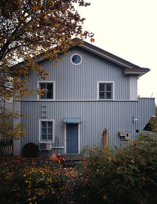 Light blue timber house with white details around the windows and door.