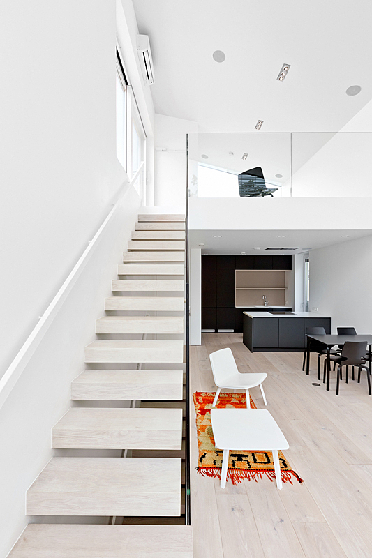 Light-coloured interior with stairs from dining area to upstairs