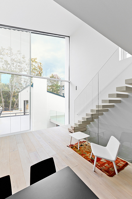 View through a large glass surface towards the white neighbour town-house type building