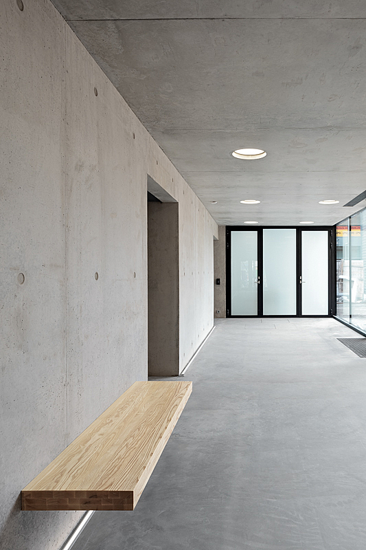 Interior with concrete walls, glass doors and ceiling spotlights