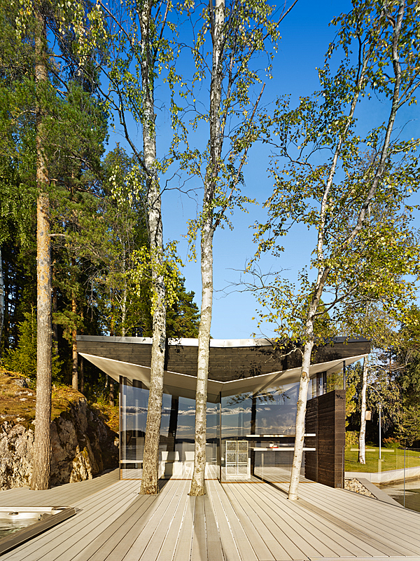 V-shaped roof and glass façade behind trees