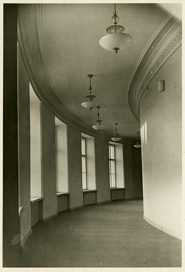 Curved corridor with grid windows.