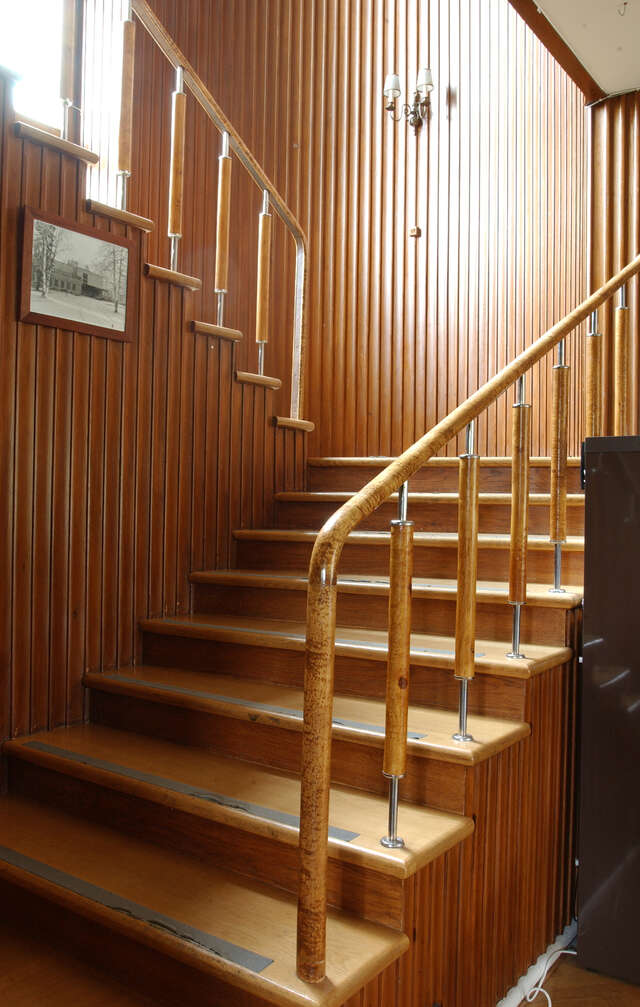 Wooden staircase that receives light from the window above the staircase.