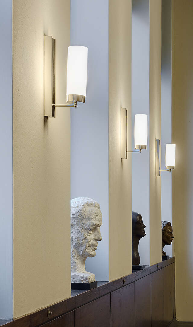 Three sculptures of faces on window sills.