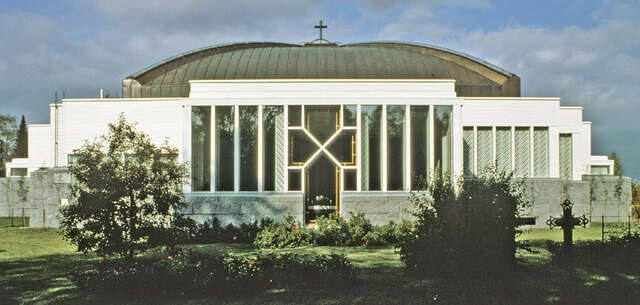 Facade with white painted timber cladding and a copper dome.