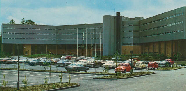 Parking lot in front of the hotel with 1970s cars.