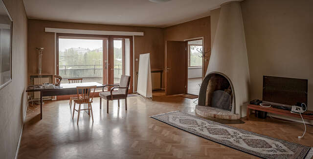 Photo of a living room, decorated with a white, round-shaped fireplace.