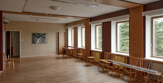 Picture of a room with wooden flooring and walls. Light flows in beautifully from the evenly distributed windows.