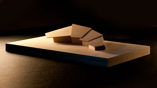 Wooden scale model of a half-moon-shaped villa