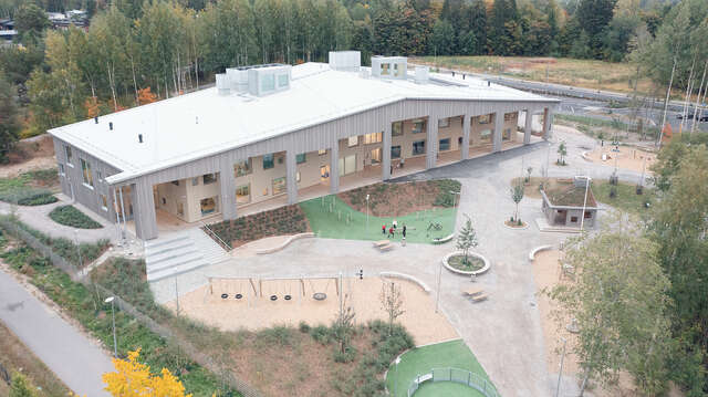 Aerial view of a wooden building with a long, sloping roof