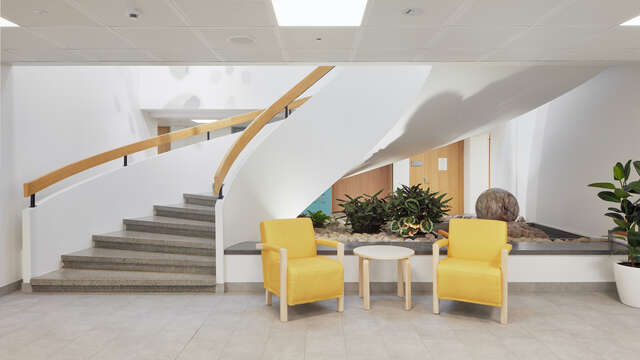 A curvy stairwell with two yellow chairs in the foreground