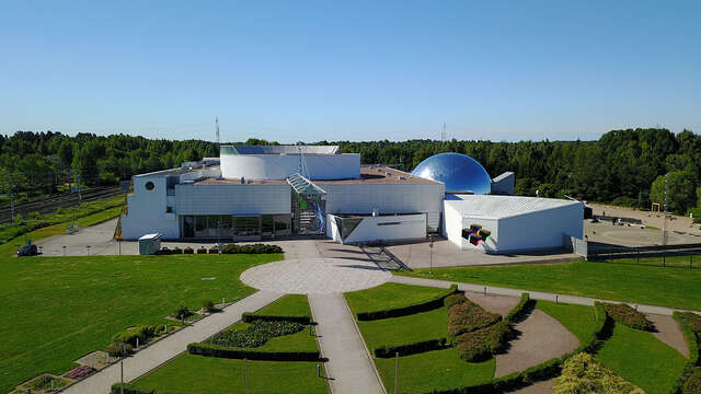 White building facade with a glass dome at the right side.