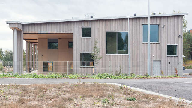 Large wooden building with different size windows.