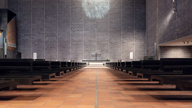 A large indoor worship room with an aisle leading to an altar. Rows of black benches are on both sides of the aisle.