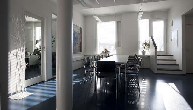 Minimalistic room with a long meeting table in the middle.