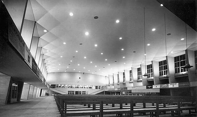 Interior of the Sports hall filled with wooden benches.