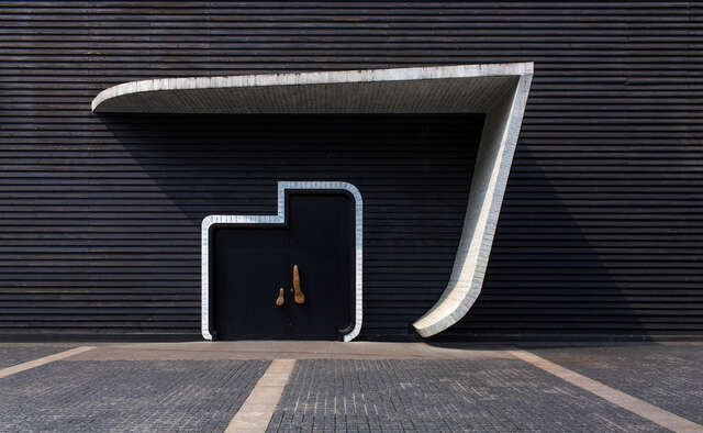 Dark façade and entrance door under a white wind of an angel