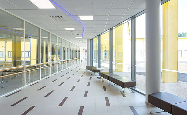 Hallway with window walls and the yellow color from outside reflecting on the walls.
