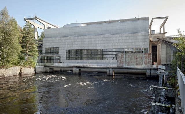 Power plant seen over the river. What is noteworthy about this picture is the façade and its architectural division on the facade. The division of tiles and window frames follow the same grid system.