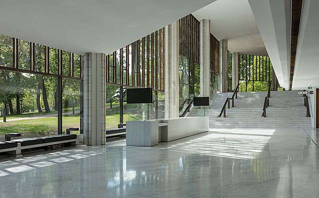 Spacious white interior with metal window frames and a marble floor.