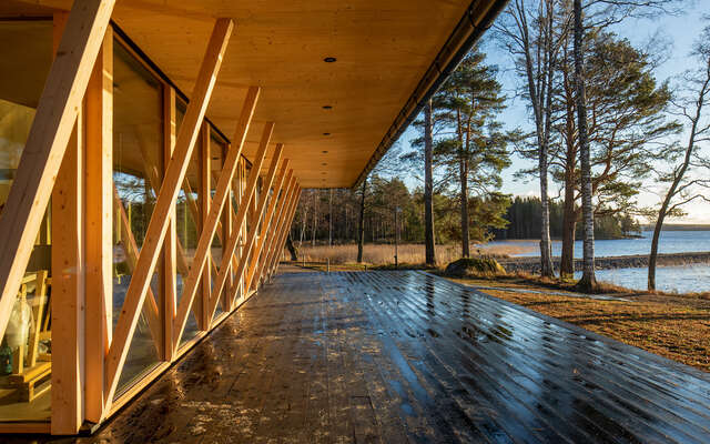 Wooden terrace with windows and wooden support structures on the left.