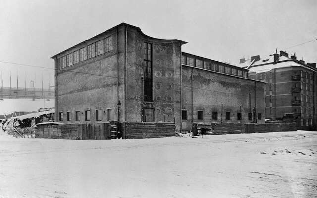 Concrete building facade with a curved wall towards the inside in a snowy landscape.