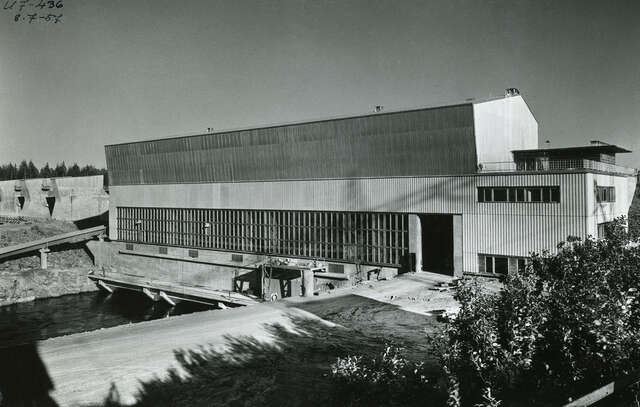 Black and white photo of the power plant building. Facade consists of concrete, ribbon windows, and a pitched roof. The building looks very simplistic and Functionalistic.