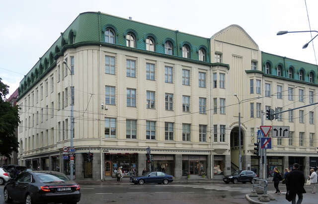 Old white multiple story building with stores at the bottom floor.