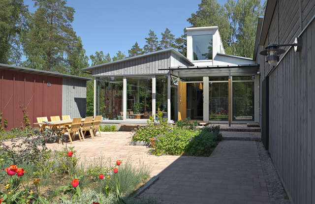 Courtyard of the villa with wooden sitting group and flower beds