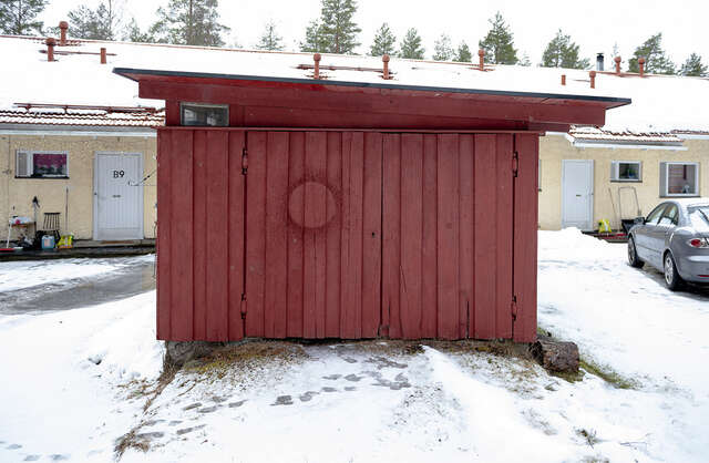 Small, red wooden building in the residential area.