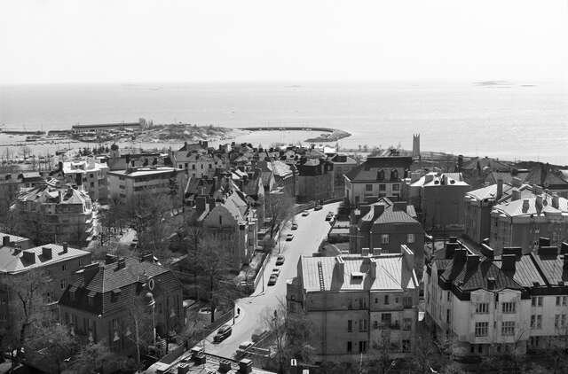 Black and white picture of the aerial vie of a wealthy neighborhood next to the sea.