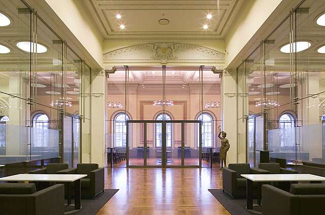 Sitting room with glass walls , a ceiling with decorative elements and angels holding the Finnish coat of arms.