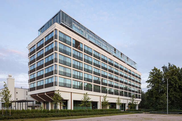 A large singular apartment building, with windows all around the building.