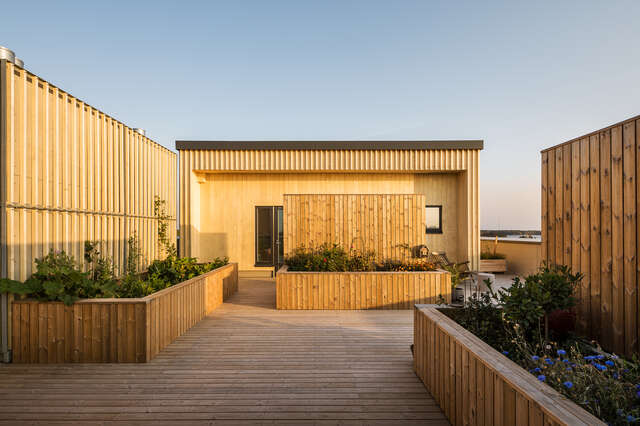 A rooftop with a wooden deck and walls.