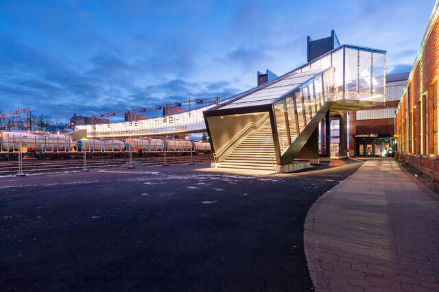 An entrance to a large bridge going over a railway