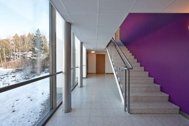 Staircase with a bright purple wall next to a snowy landscape outside.