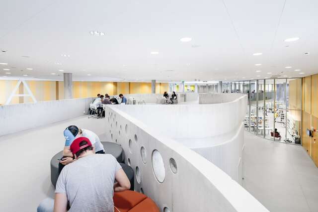 Hallway with seating areas and a concrete railing.