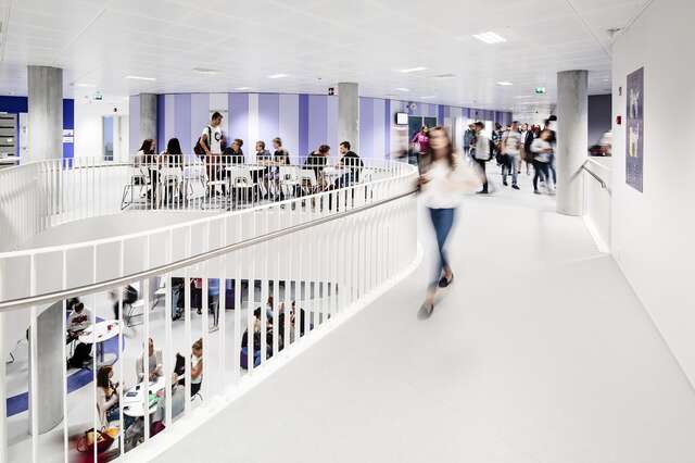 Students walking in the white hallway.