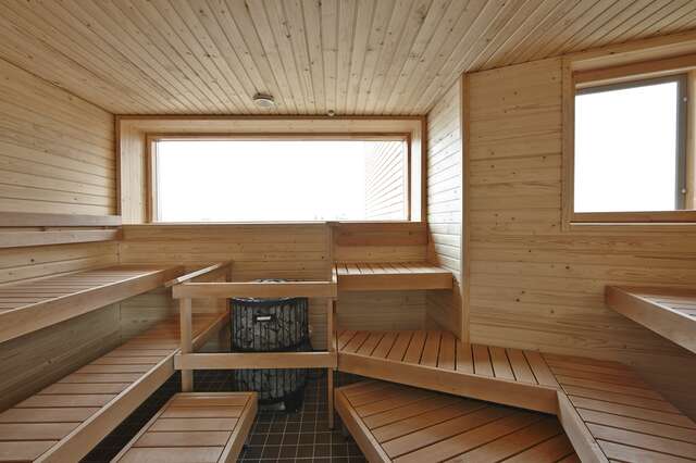 Large wooden sauna interior with seats on opposing sides.