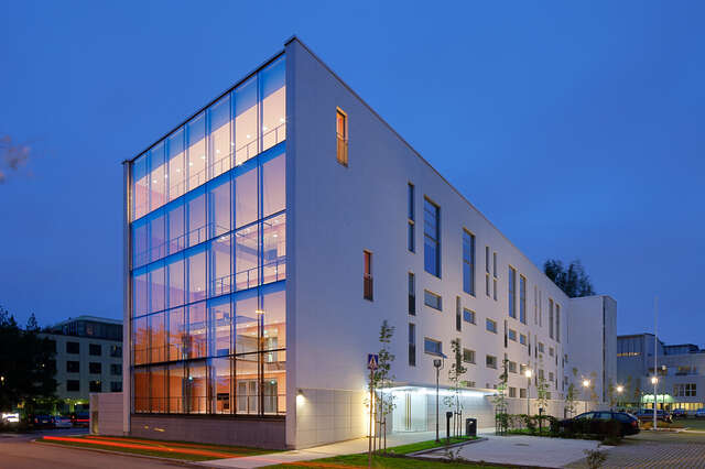 White residential building with glass and multiple square window façades in evening light