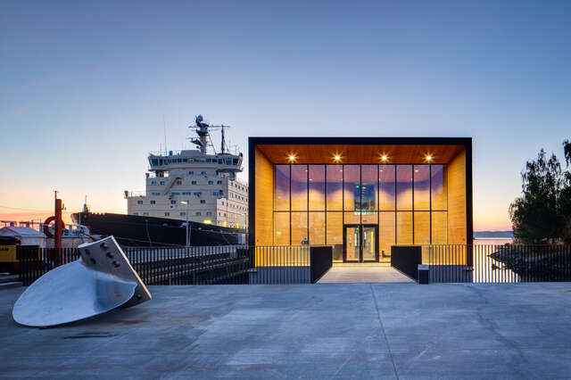 Illuminated glass walled main entrance with an icebreaker in the background