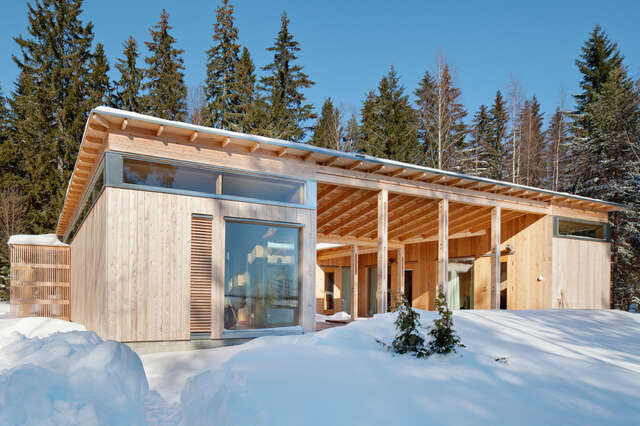 High-scale window and central atrium of the timber building in snowy landscape