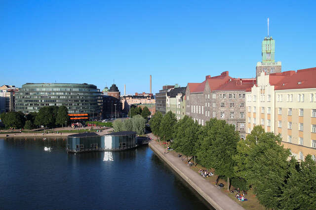 Birds eye view of the restaurant , its glass windows reflect the sun onto the sea.