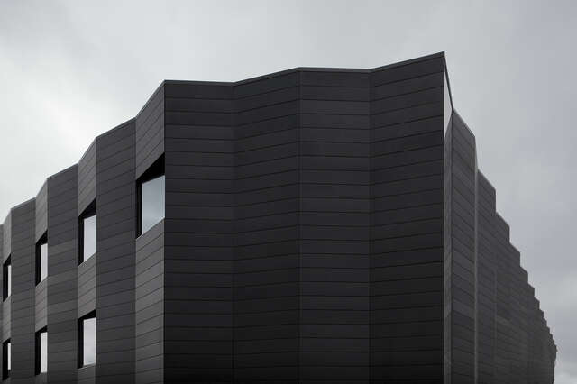 Dark, metal-sheeted facade with sharp folds